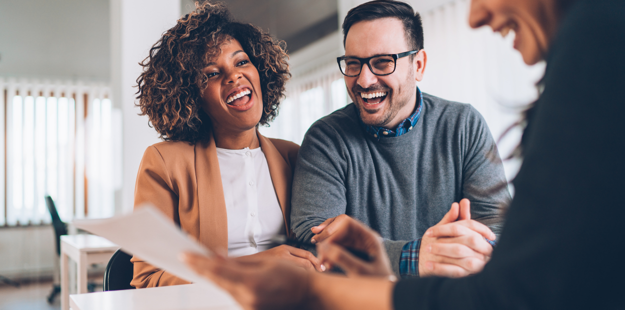 A man and a woman are sitting at a table talking to an advisor.